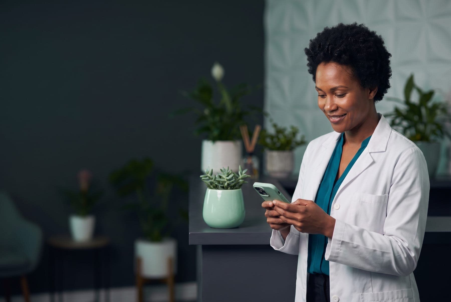 Médica na recepção da clínica conferindo a agenda no celular