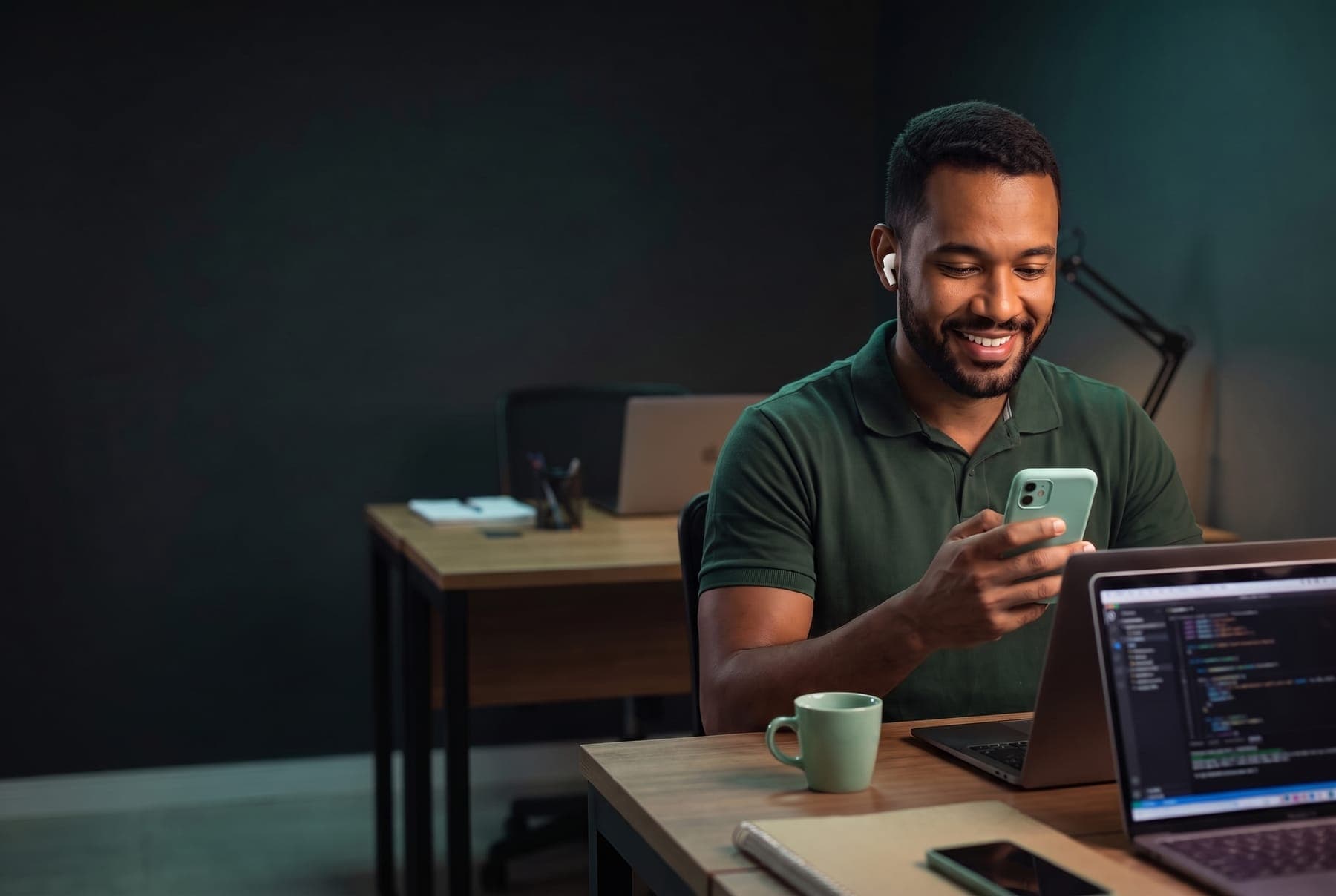 Vendedor numa mesa de escritório à noite, lendo a mensagem de um cliente no celular